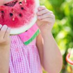 Healthy Eating Children - Girl Eating Sliced Watermelon Fruit Beside Table