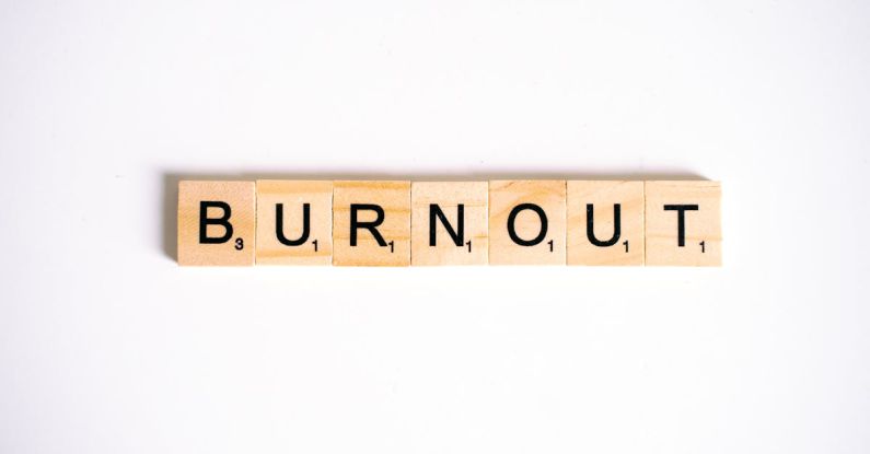 Burnout - Close-Up Shot of Scrabble Tiles on a White Surface