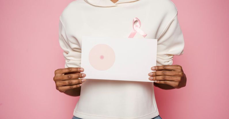 Cancer Prevention - Black female holding paper with painted one breast as symbol of cancer