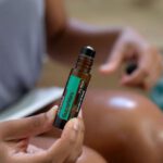 Peppermint Oil - Close-up of Woman Holding a Glass Bottle of Peppermint Essential Oil with a Roller