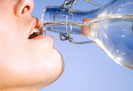 Drinking Water - Woman Drinking Water From Glass Bottle